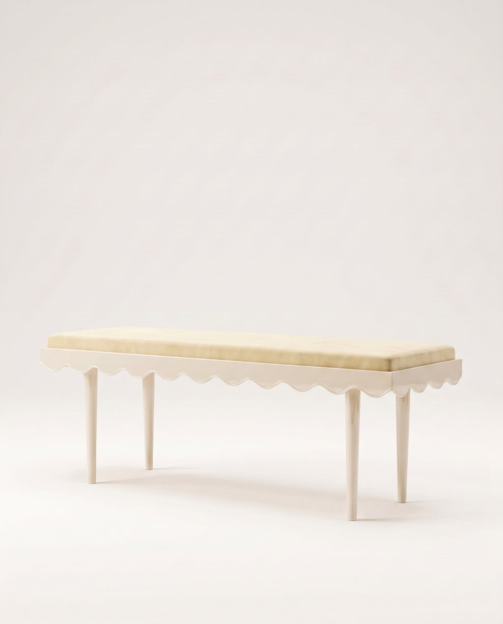 Romance upholstered bench in off-white velvet with scalloped skirt and slender off-white lacquer legs, Monde Singulier Editions, three-quarter view