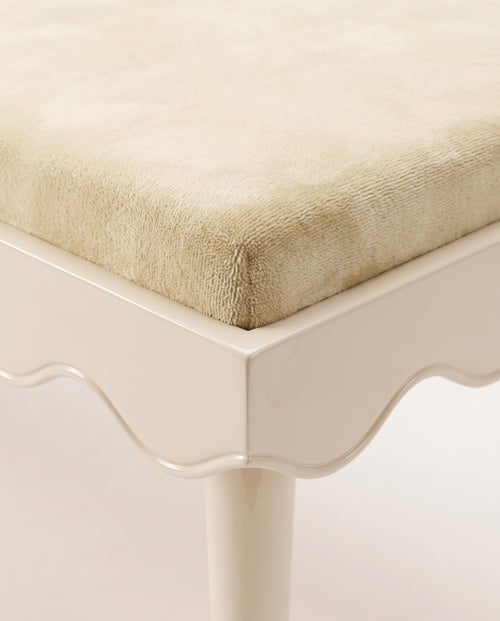 Romance bench in off-white, close-up of the velvet seat, scalloped lacquer skirt and tapered leg, Monde Singulier Editions