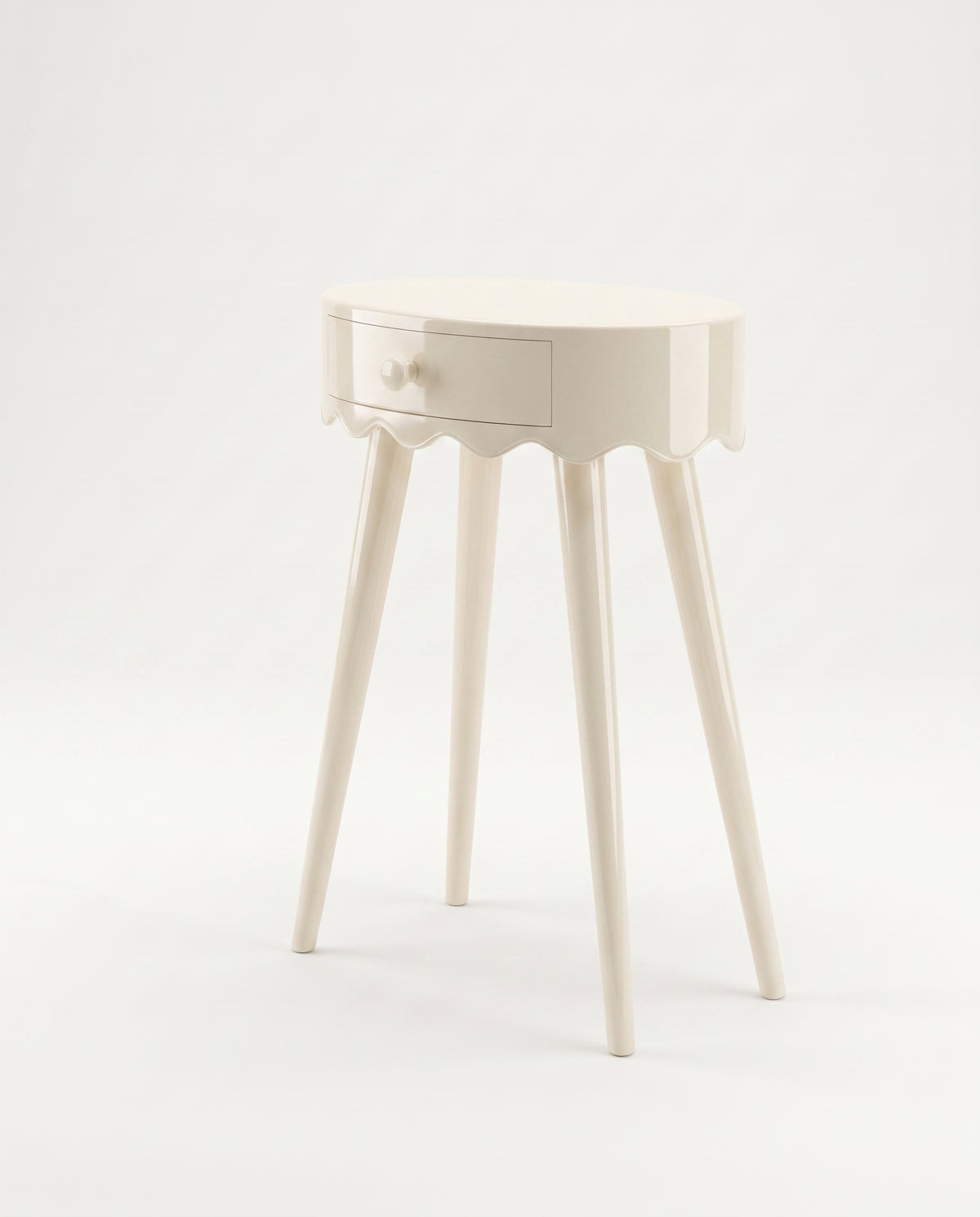 Romance round bedside table in off-white lacquer with scalloped apron, single drawer and three splayed legs, Monde Singulier Editions