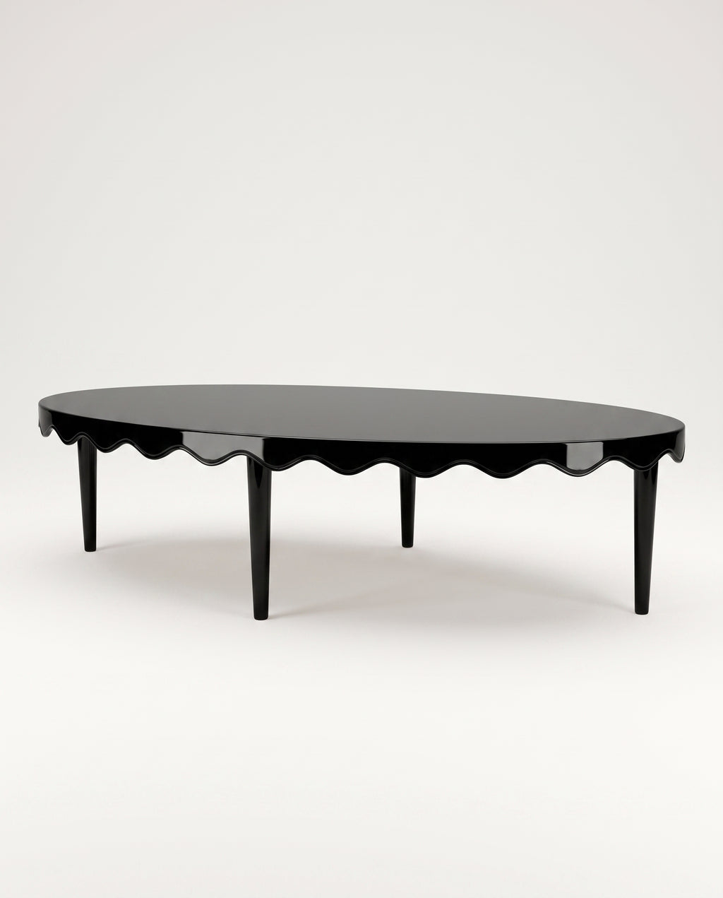 Romance oval coffee table in black lacquer with scalloped apron and tapered legs, Monde Singulier Editions, three-quarter view