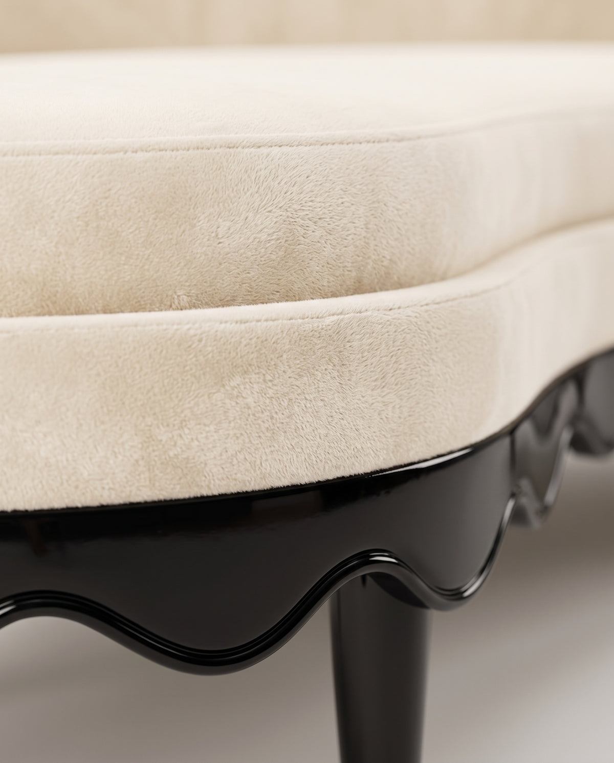 Romance sofa in ecru velvet, close-up of the seat cushion edge and scalloped black lacquer base, Monde Singulier Editions