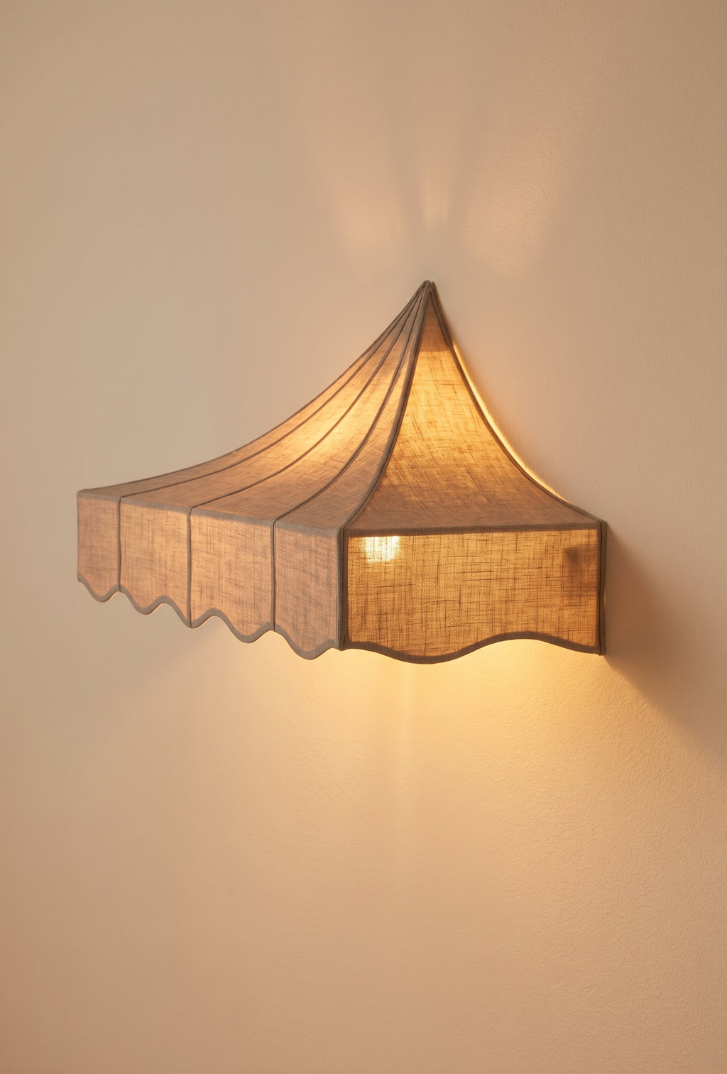 Romance wall sconce in off-white lit, warm glow through the scalloped paper shade against the wall, Monde Singulier Editions