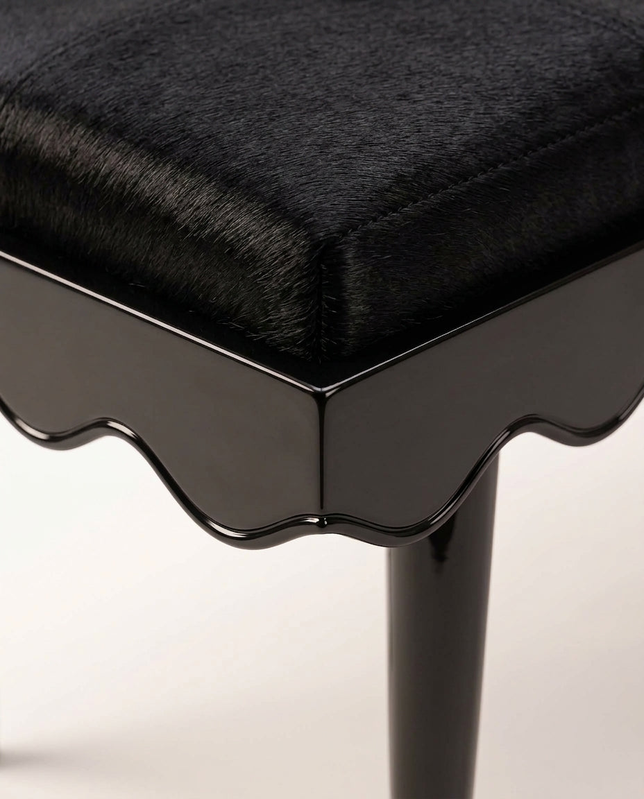 Romance bench in black, close-up of the upholstered seat, scalloped black lacquer skirt and tapered leg, Monde Singulier Editions