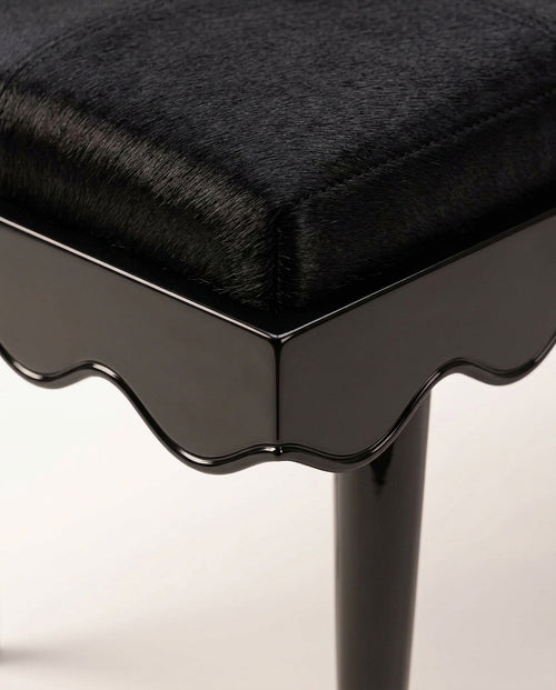Romance bench in black, close-up of the upholstered seat, scalloped black lacquer skirt and tapered leg, Monde Singulier Editions