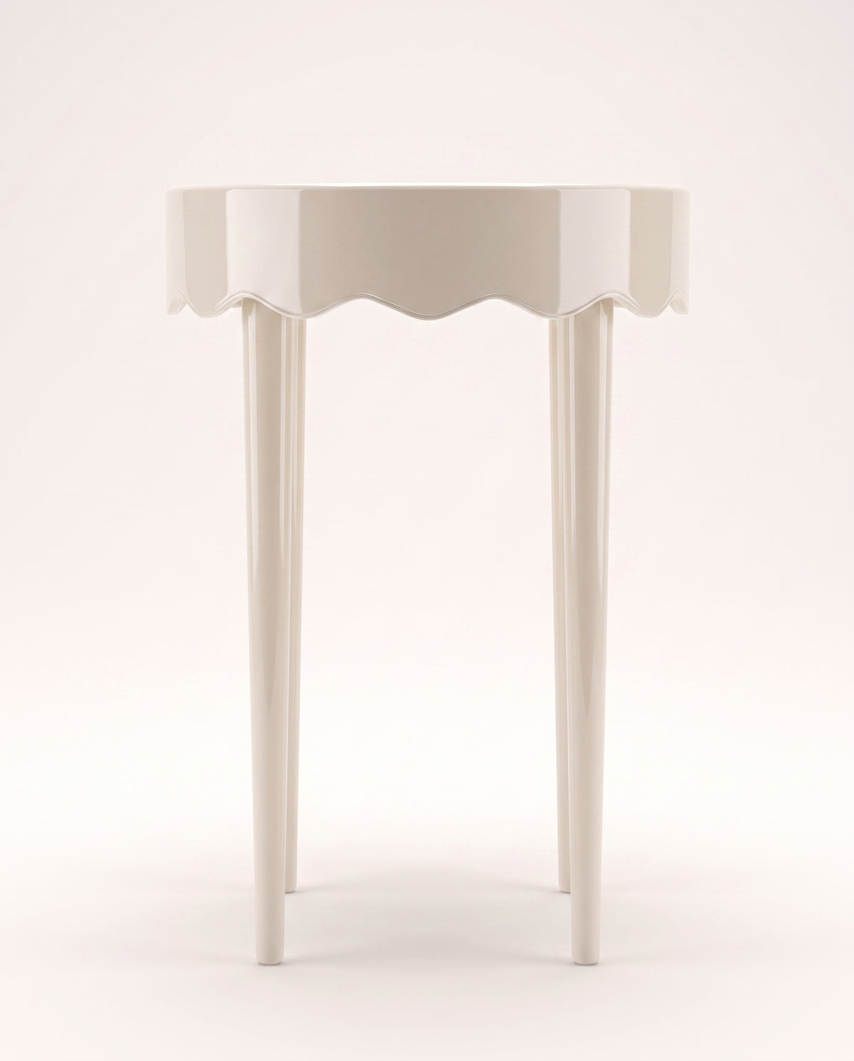 Romance round side table in off-white lacquer with scalloped apron and three tapered legs, Monde Singulier Editions, front view