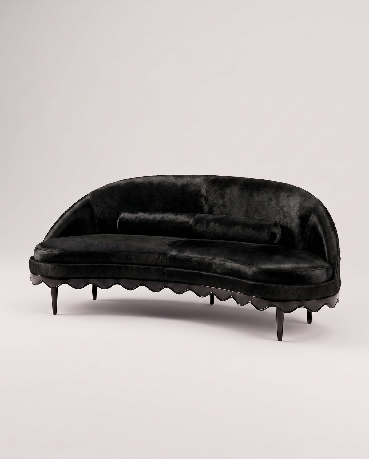 Canapé Romance en peau de vache noire, coussin traversin et base festonnée en laque noire, Monde Singulier Editions