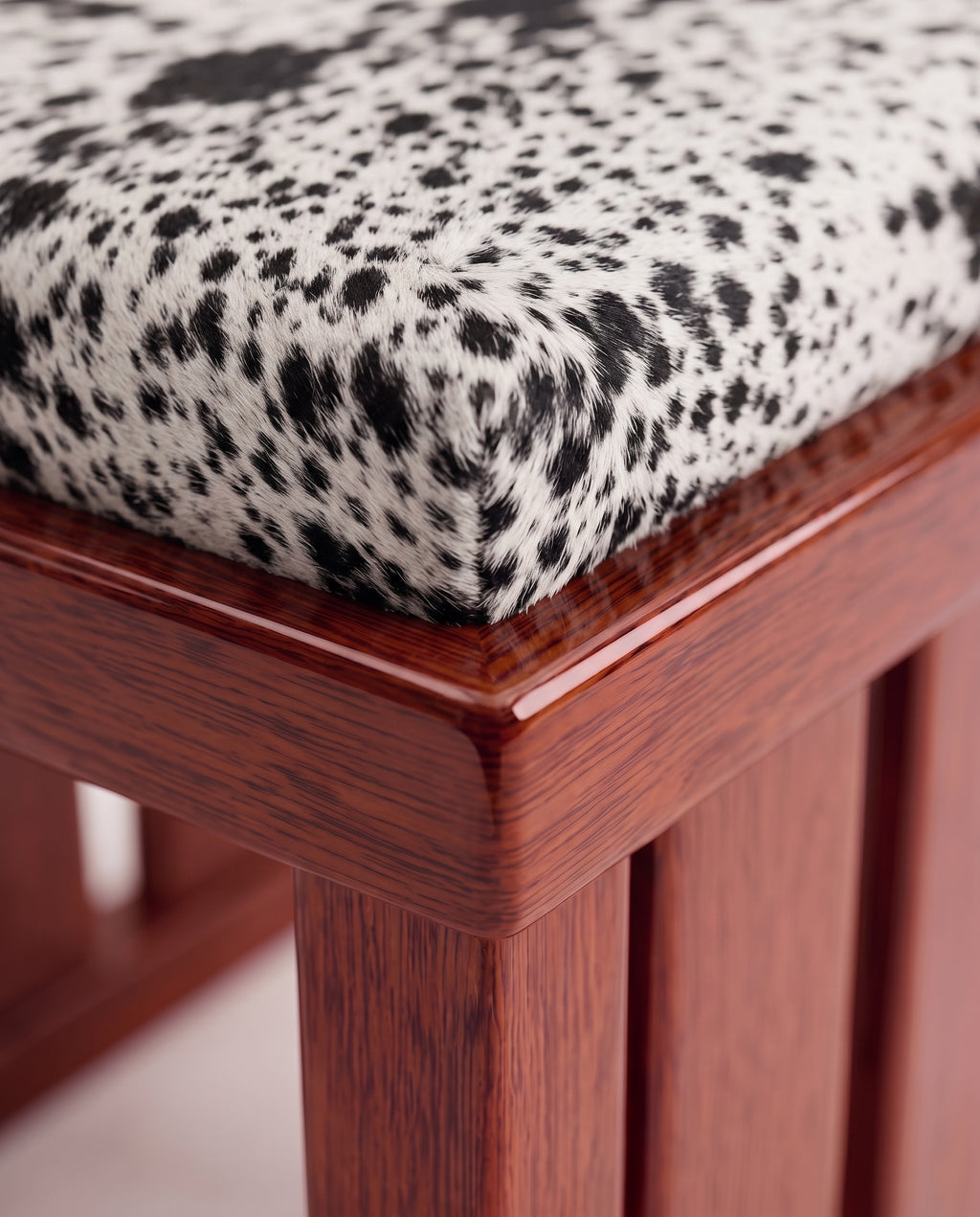 Cardinal chair, close-up of the spotted cow hide seat and mahogany lacquer slatted base, Monde Singulier Editions