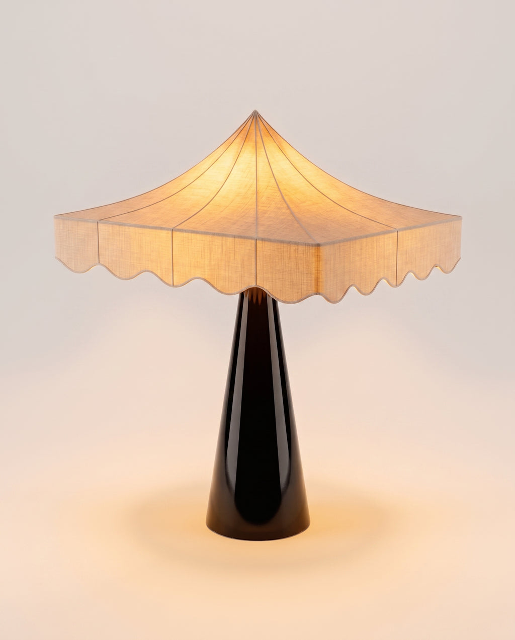 Romance table lamp lit, warm glow through the scalloped paper shade above the black lacquer base, Monde Singulier Editions
