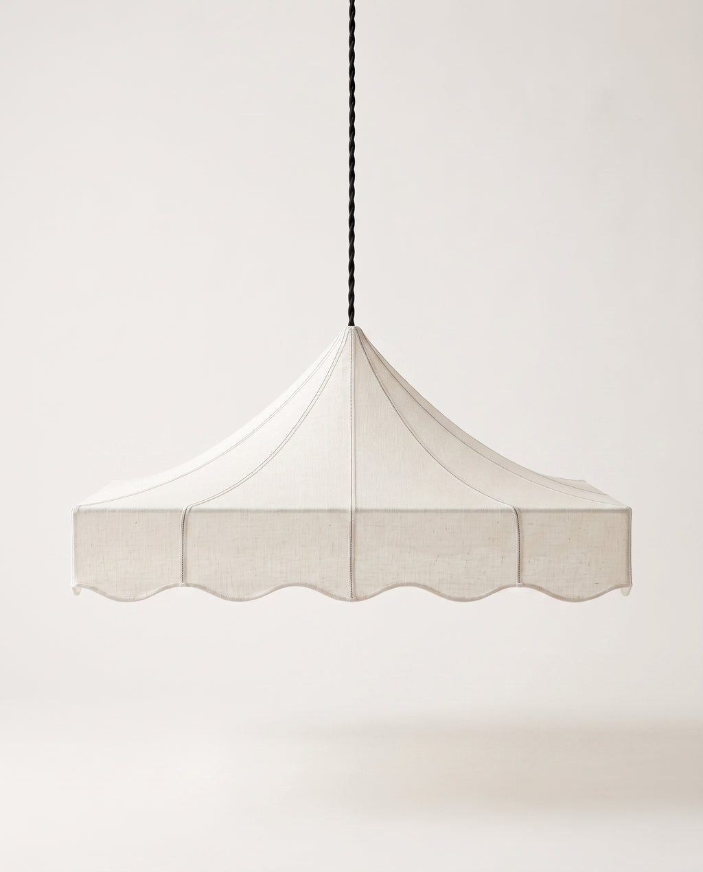 Romance pendant lamp, scalloped tent shade in off-white paper hanging from a slender black cord, Monde Singulier Editions, front view
