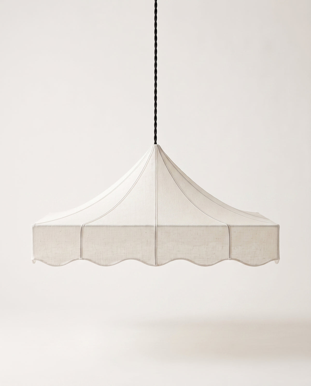 Romance pendant lamp, scalloped tent shade in off-white paper hanging from a slender black cord, Monde Singulier Editions, front view