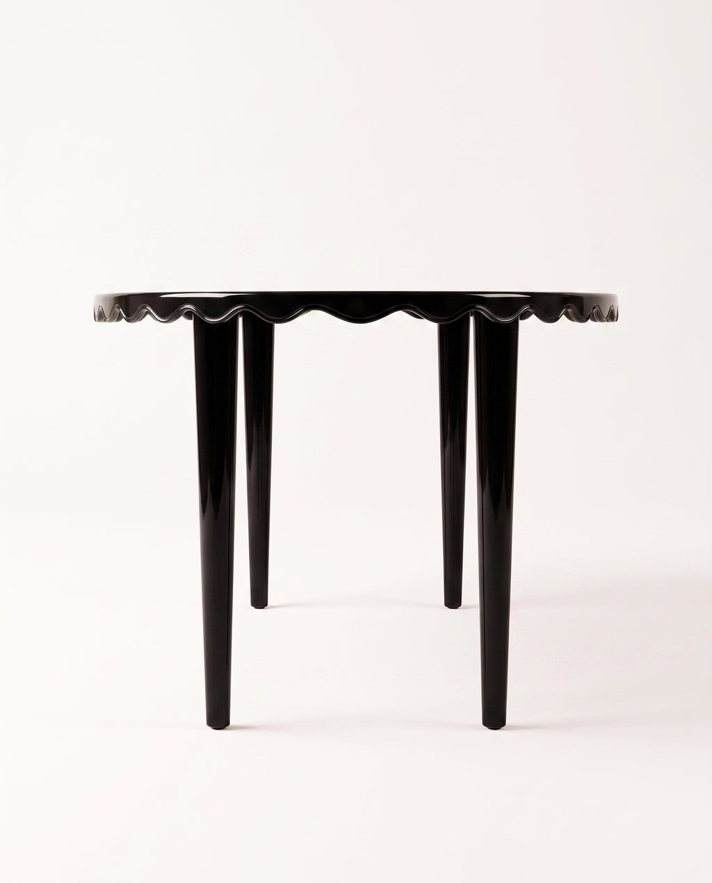 Romance dining table in black lacquer, side view of the scalloped apron and tapered legs, Monde Singulier Editions