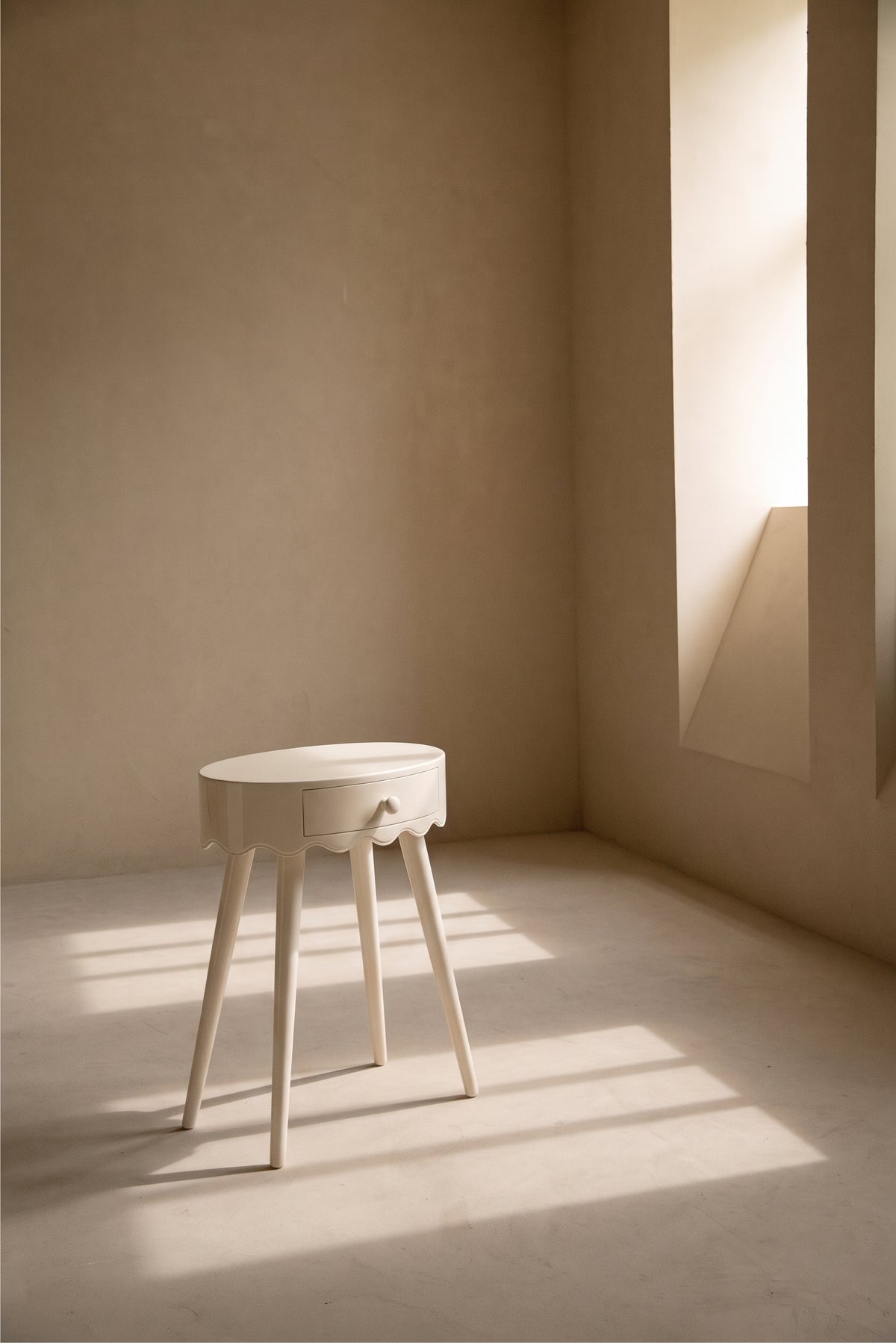 Table de chevet Romance blanc cassé dans une pièce baignée de lumière naturelle, Monde Singulier Editions